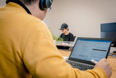 Beispielbild: Blick über die Schulter bei Personen am Arbeiten in unserem Co-Working-Space