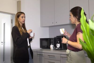 Beispielbild: zwei Personen unterhalten sich beim Kaffee trinken in der Küche unseres Co-Working-Space