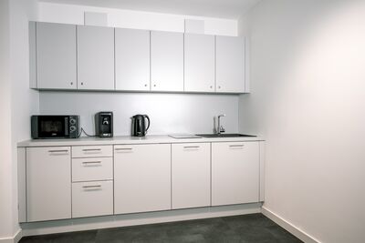 Küche mit Mikrowelle, Senseo Kaffee Maschine, Wasserkocher, Herd, Spülbecken, Spülmaschine und Kühlschrank im Co-Working-Space